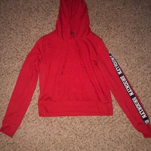 a red hoodie with “brooklyn”going down the sleeves